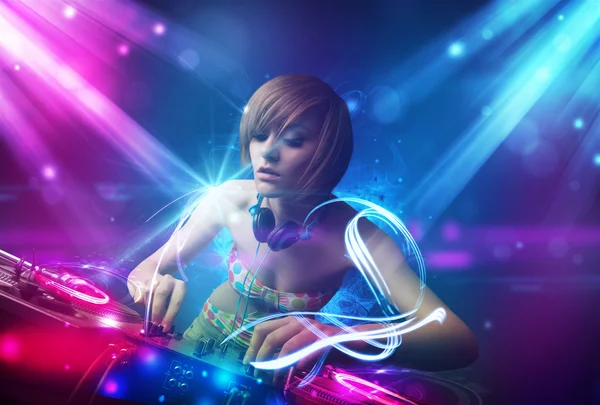 Energetic Dj girl mixing music with powerful light effects — Stock Photo, Image