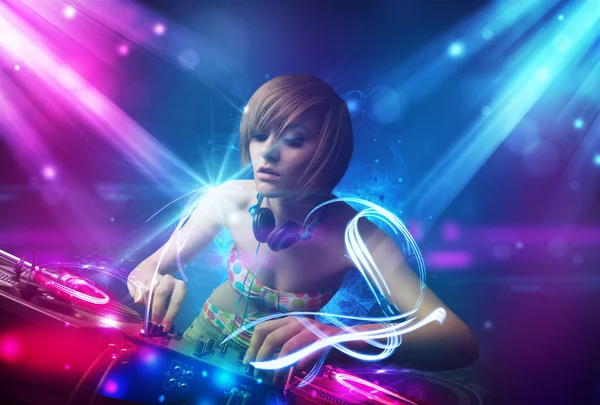 Energetisches DJ-Girl mischt Musik mit starken Lichteffekten — Stockfoto