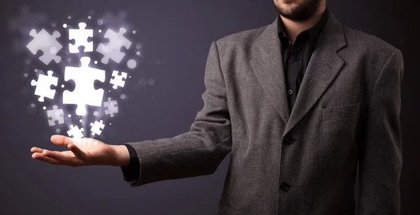 Puzzle pieces in the hand of a businessman — Stock Photo, Image