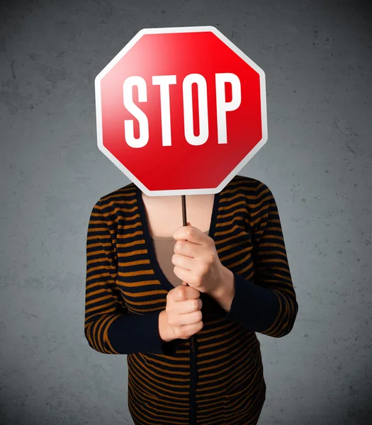 Elinde dur tabelası tutan genç bir kadın.