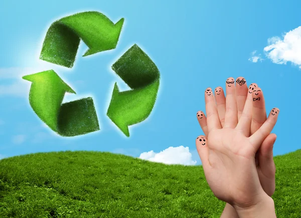 Heureux doigts souriants regardant feuille verte recycler signe — Photo