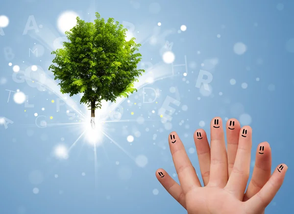 Happy finger smileys with green magical glowing tree — Stock Photo, Image