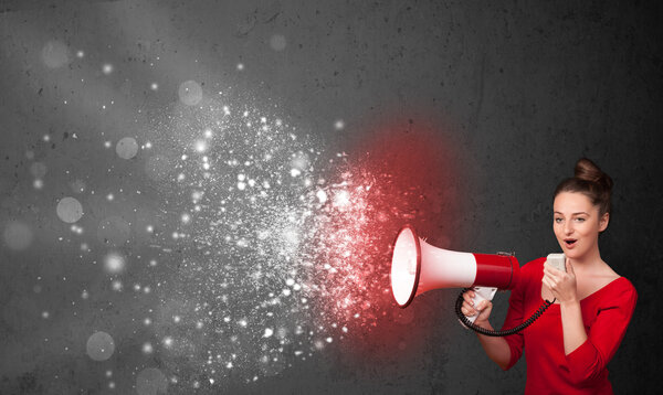 Женщина кричит в мегафон и исследует светящиеся частицы энергии
