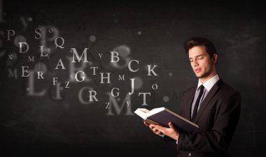 genç adam alfabesi harfleri ile kitap okuma