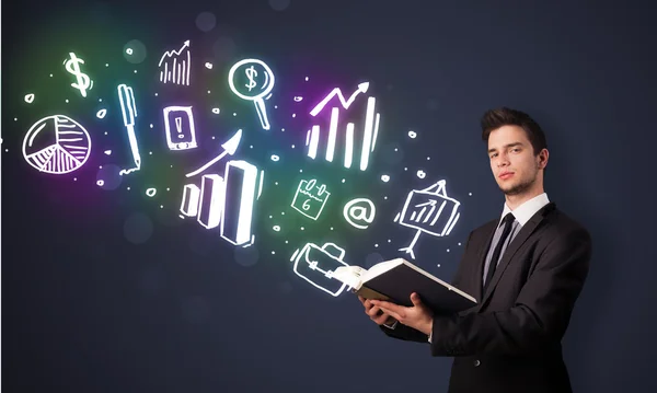 Young guy reading a book with business icons — Stock Photo, Image