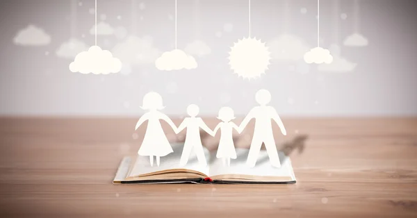 Cardboard figures of the family on opened book — Stock Photo, Image