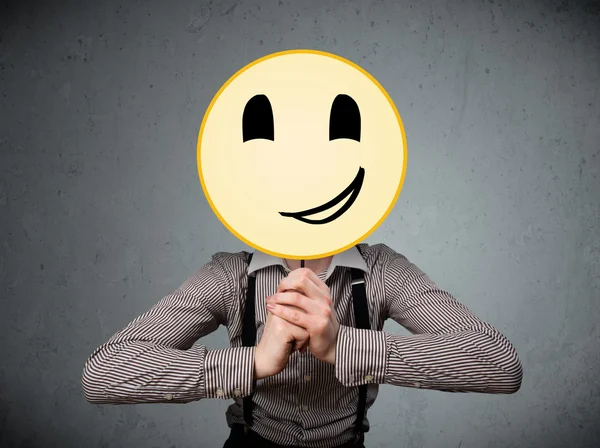 Empresário segurando um emoticon rosto sorridente — Fotografia de Stock