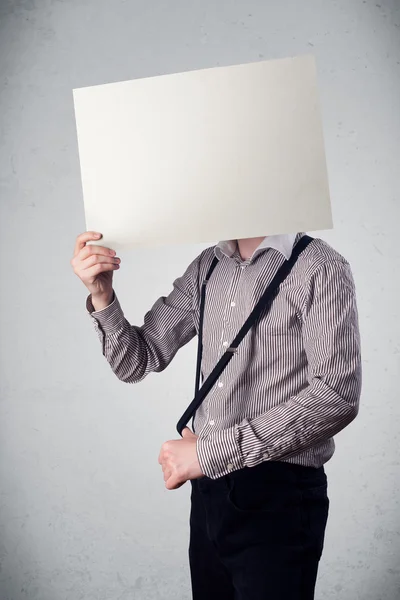 Geschäftsmann hält sich ein Papier mit Kopierplatz vor den Kopf — Stockfoto