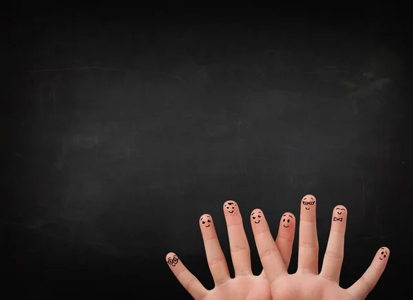 Happy smiley fingers looking at empty black chalboard — Stock Photo, Image