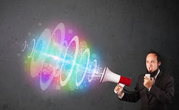 Man yells into a loudspeaker and colorful energy beam comes out — Stock Photo, Image