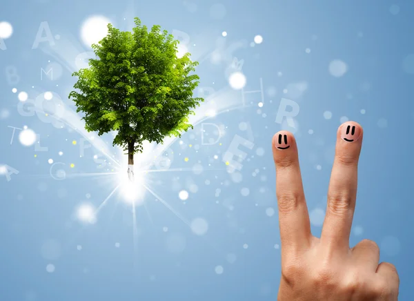 Sorrisos dedo feliz com verde mágico brilhante árvore — Fotografia de Stock