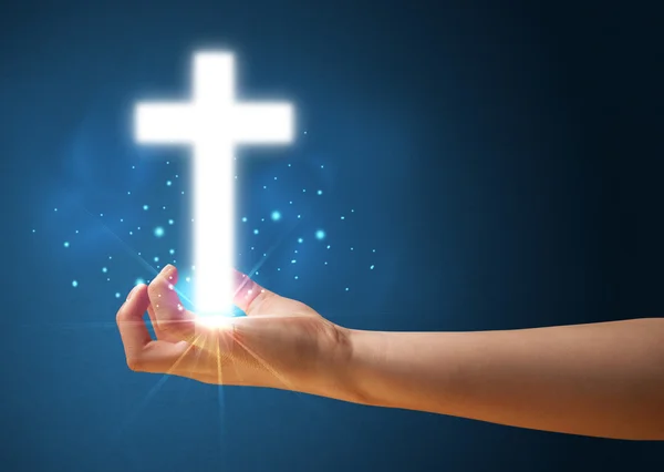 Brilhando cruz na mão de uma mulher — Fotografia de Stock
