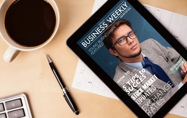 Tablet-PC zeigt Magazin auf dem Bildschirm mit einer Tasse Kaffee auf einem d — Stockfoto