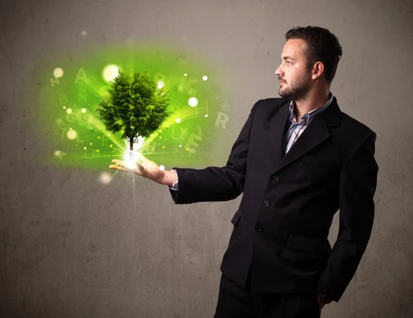 Glowing tree growing in the hand of a businessman — Stock Photo, Image