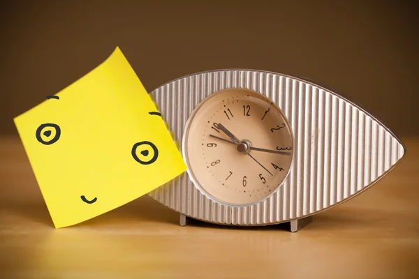 Post-it con faccina sorridente incollata su un orologio — Foto Stock