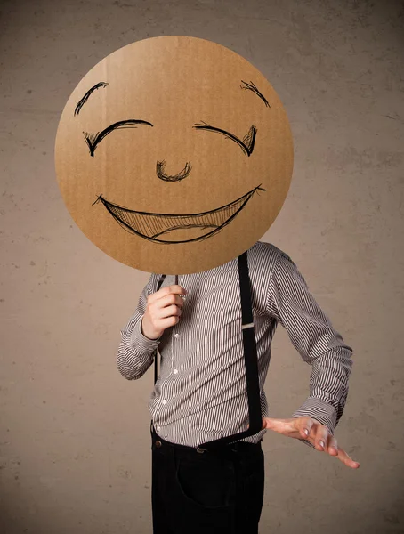 Businessman holding a smiley face board — Stock Photo, Image