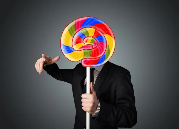 Businessman holding a lollipop — Stock Photo, Image