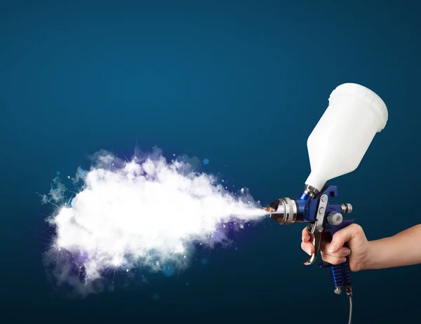 Painter with airbrush gun and white magical smoke — Stock Photo, Image