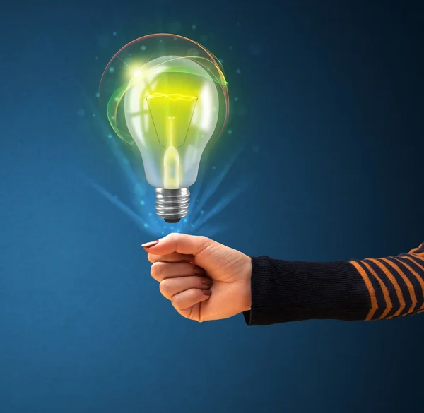 Glowing lightbulb in the hand of a woman — Stock Photo, Image