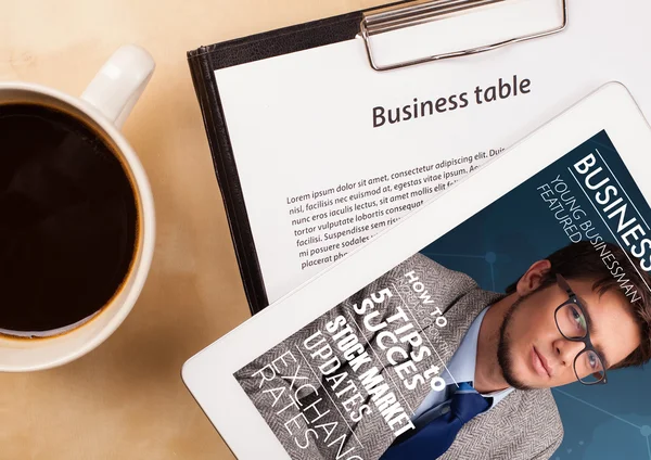 Tablet pc showing magazine on screen with a cup of coffee on a d — Stock Photo, Image