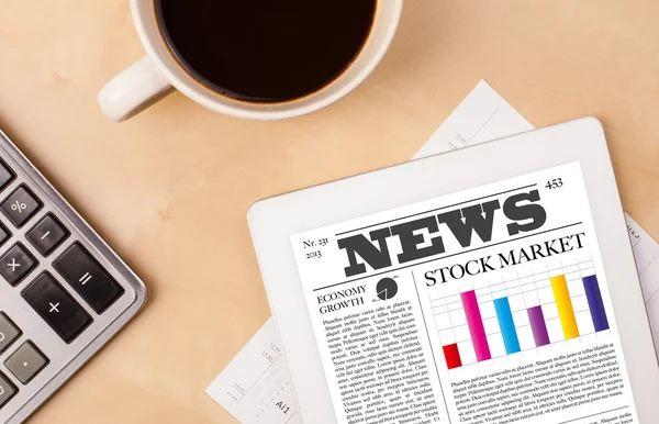 Tablet pc shows news on screen with a cup of coffee on a desk — Stock Photo, Image