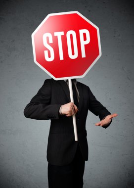İşadamı elinde dur levhası tutuyor.