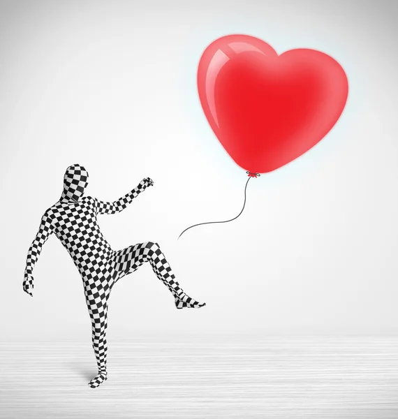 Cute guy in morpsuit body suit looking at a balloon shaped heart — Stock Photo, Image