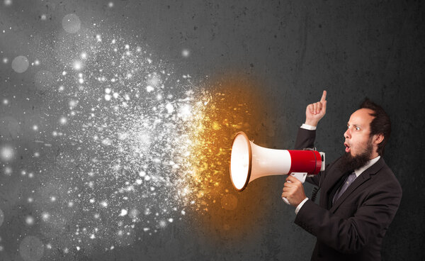 Парень, кричащий в мегафон и пылающие частицы энергии взрываются