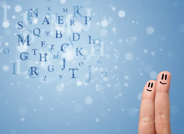 Happy smiley fingers looking at mixture of bokeh letters — Stock Photo, Image