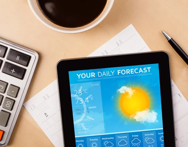 Tablet PC que muestra el pronóstico del tiempo en pantalla con una taza de café —  Fotos de Stock