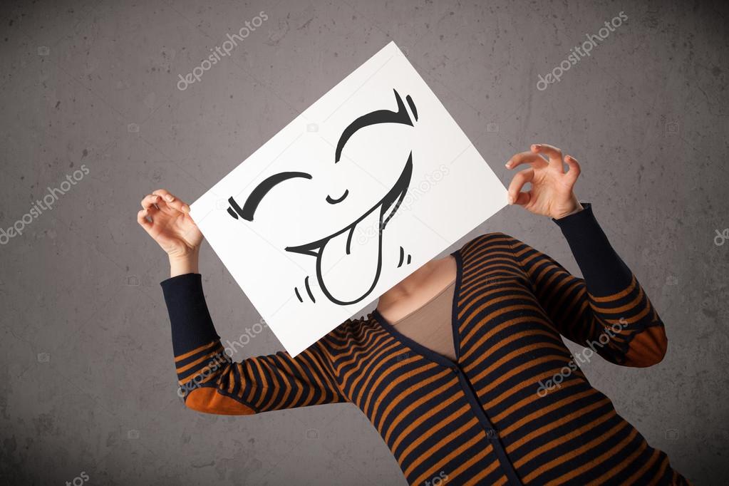 Woman holding a paper with cute smiley face on it in front of he