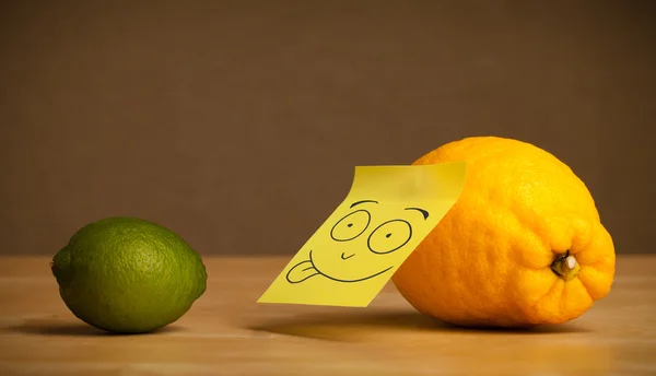 Lemon with post-it note sticking out tongue to lime — Stock Photo, Image