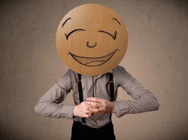 Affärsman som innehar en smiley face styrelse — Stockfoto