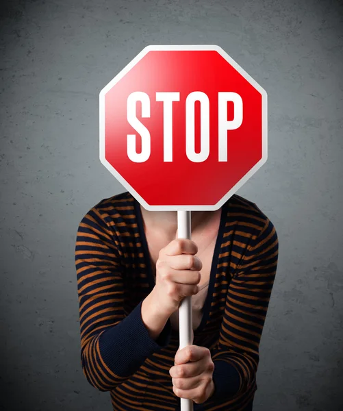 Jeune femme tenant un panneau stop — Photo