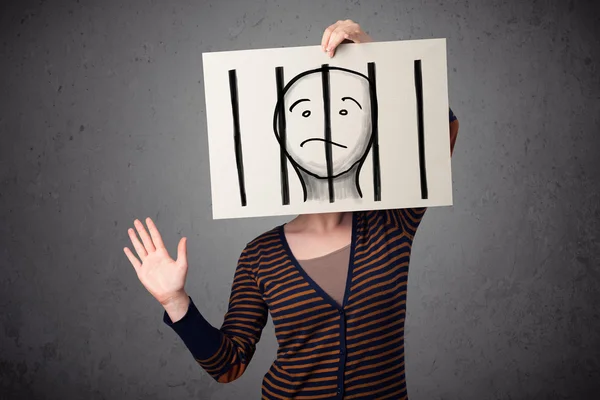 Woman holding a paper with a prisoner behind the bars on it in f — Stock Photo, Image