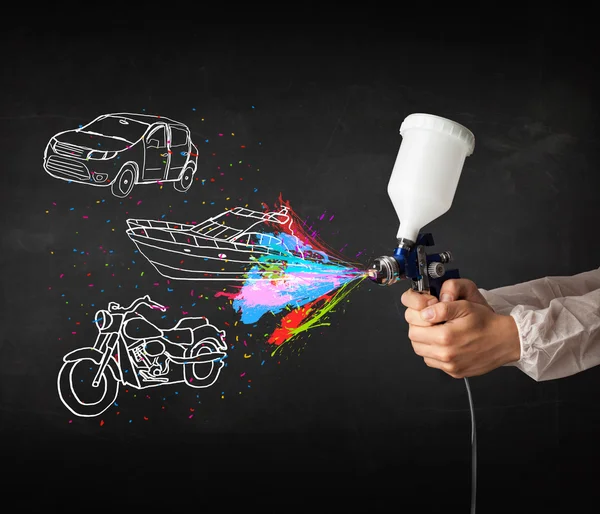 Uomo con aerografo vernice spray con auto, barca e moto disegnare — Foto Stock