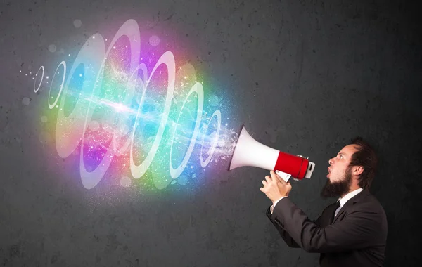 Man yells into a loudspeaker and colorful energy beam comes out — Stock Photo, Image