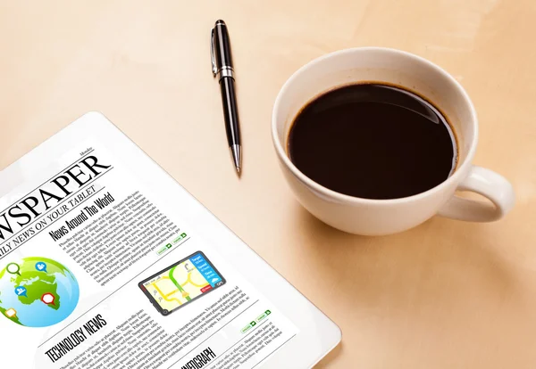 Tablet PC muestra noticias en pantalla con una taza de café en un escritorio — Foto de Stock