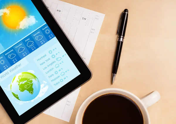 Tablette pc montrant les prévisions météorologiques à l'écran avec une tasse de café — Photo