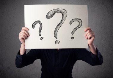 onun önünde soru işareti olan bir kağıt tutan işadamı 