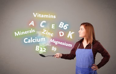 Genç bir kadın vitamin ve mineral pişiriyor.