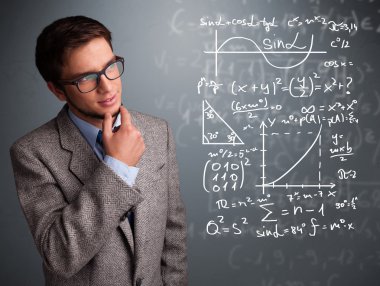 Karmaşık matematiksel işaretleri düşünen yakışıklı okul çocuğu.