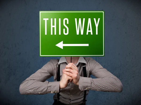 Businessman holding a direction sign — Stock Photo, Image