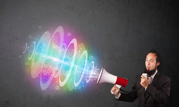 Man yells into a loudspeaker and colorful energy beam comes out — Stock Photo, Image