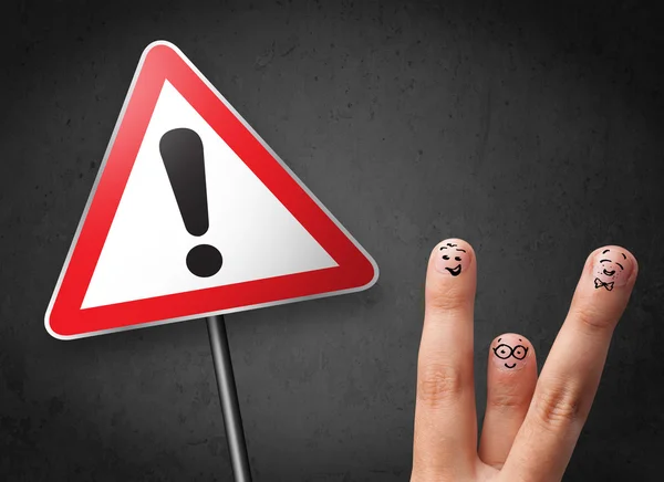 Happy smiley fingers looking at triangle warning sign with excla — Stock Photo, Image