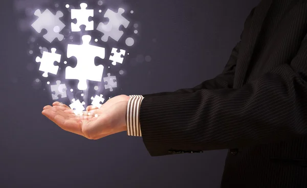 Puzzle pieces in the hand of a businessman — Stock Photo, Image