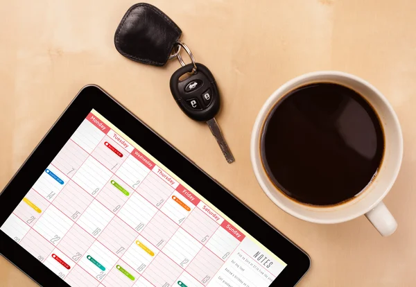 Tablet pc weergegeven: agenda op scherm met een kopje koffie op een d — Stockfoto