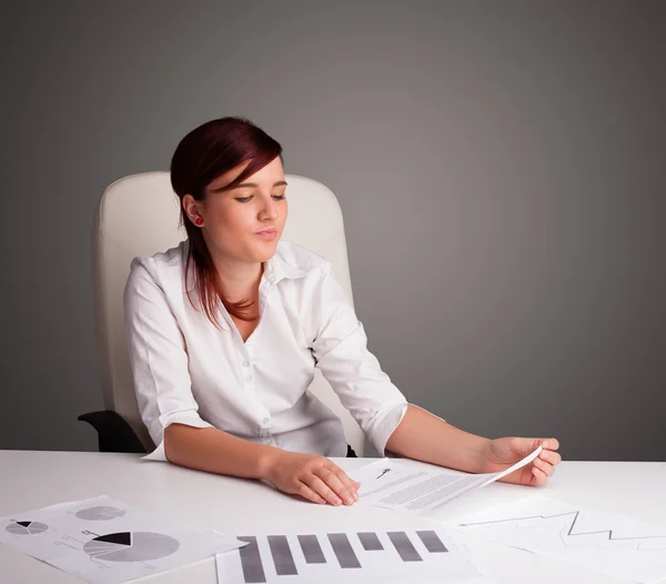 Mulher de negócios sentada na mesa e fazendo papelada — Fotografia de Stock