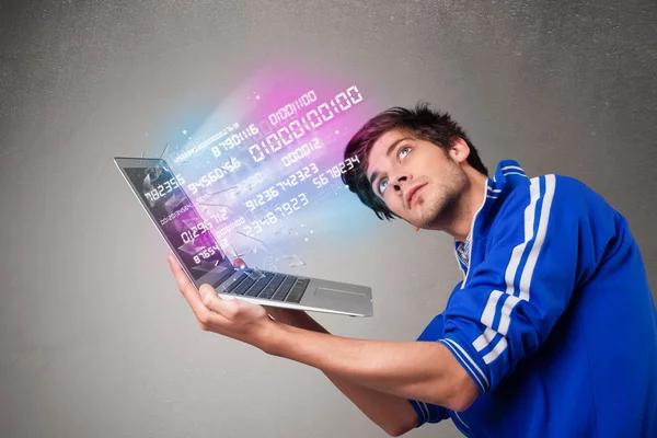 Zwykły człowiek trzymający laptopa z wybuchającymi danymi i numerami — Zdjęcie stockowe