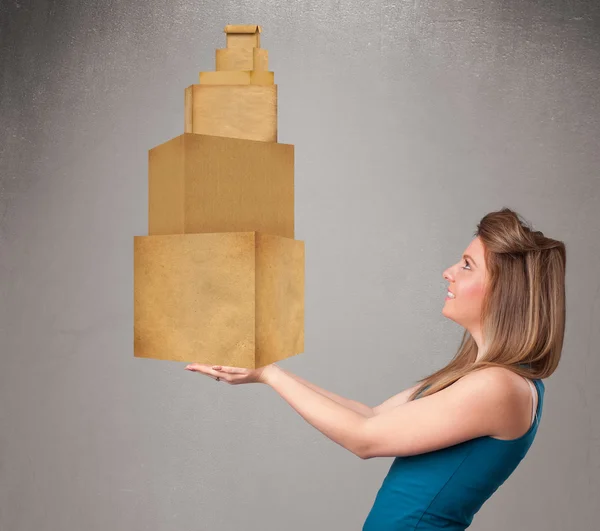 Jovencita sosteniendo un juego de cajas de cartón marrón — Foto de Stock